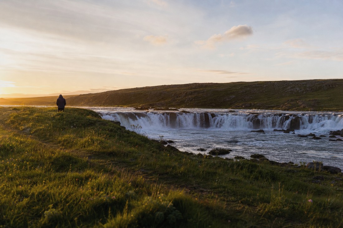 Wide low Faxi waterfall on the Tungufljót river glowing in late golden evening light