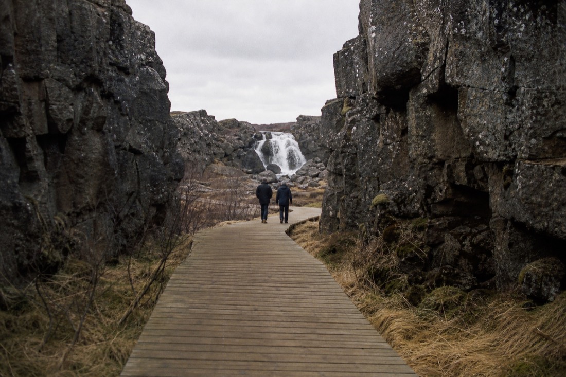 Boardwalk path leading through the rift toward Öxarárfoss waterfall at Þingvellir