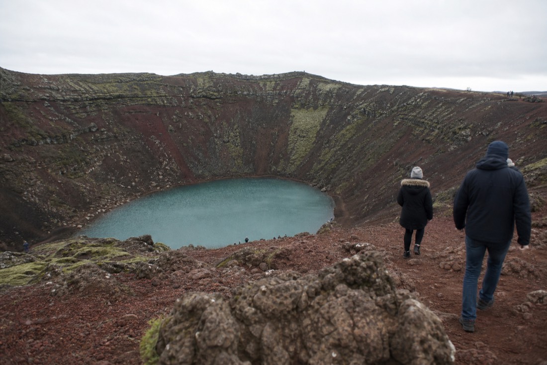 Red volcanic slopes and aquamarine crater lake at Kerið under flat overcast light