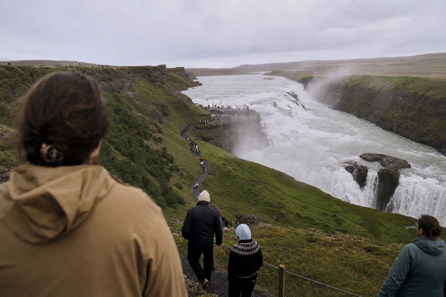 Spray rising from the double cascade of Gullfoss into the Hvítá canyon under a grey sky
