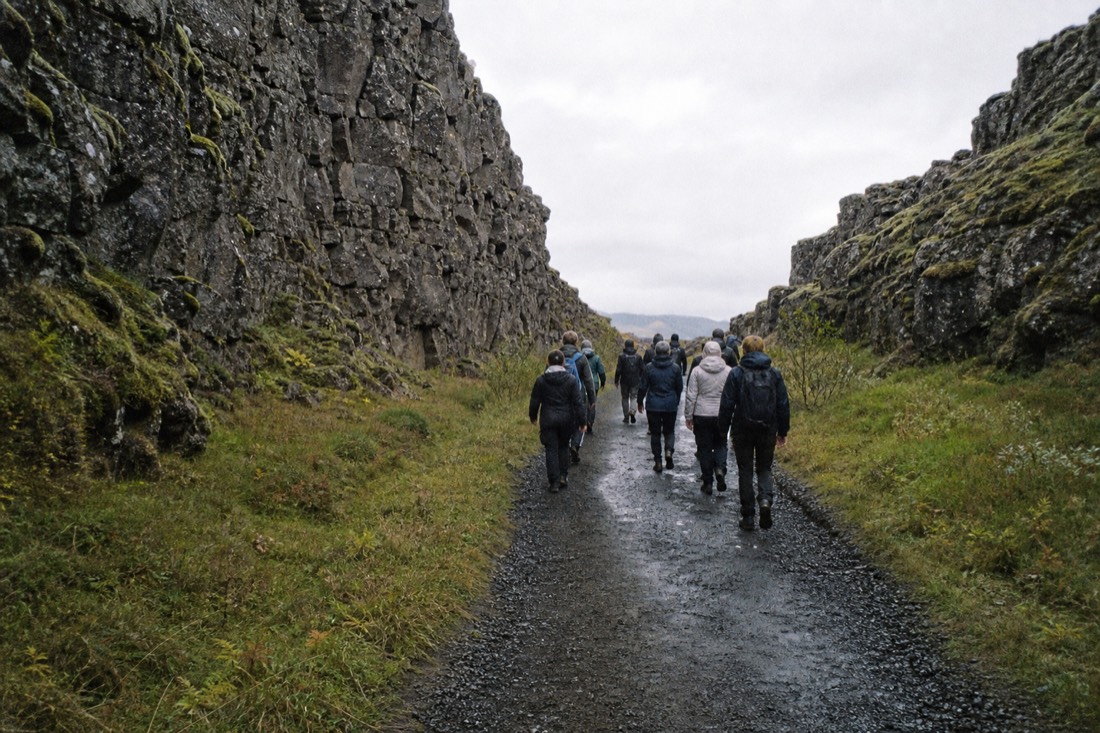 Walkers on the gravel path through the Almannagjá rift at Þingvellir National Park