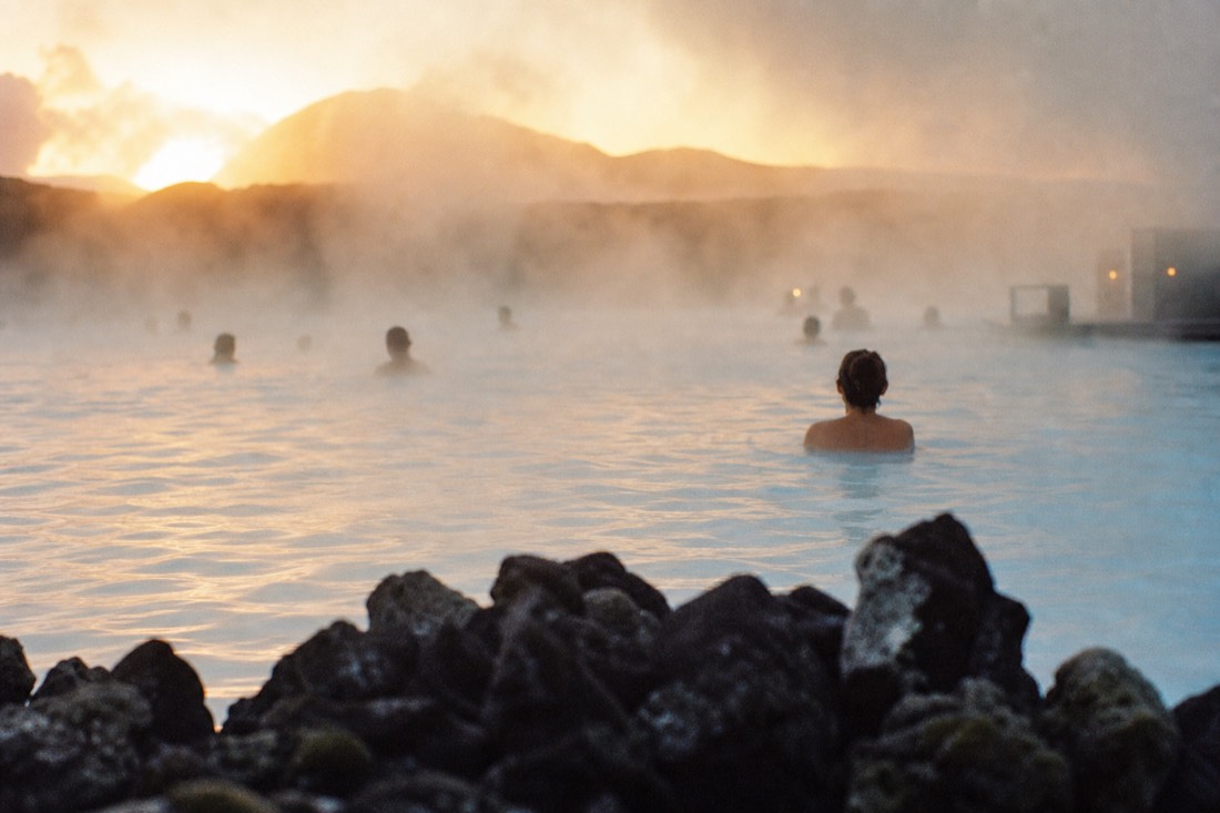 Steam rising off the milky blue geothermal water of the Blue Lagoon in Iceland at dusk